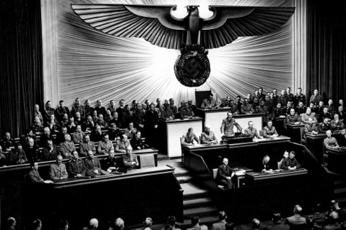 Hitler presiding at the Reichstag. Bundesarchiv, Bild 183-1987-0703-507 / unbekannt / CC-BY-SA 3.0 Photo of Hitler presiding at the Reichstag.